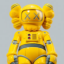 Load image into Gallery viewer, A bright yellow KAWS-style robot toy figure with gray accents, including the eyes and chest details, shown against a solid gray background.
