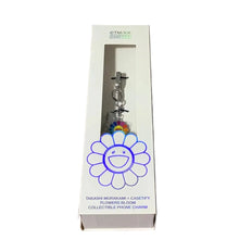 Load image into Gallery viewer, Takeshi Murakami x Casetify 'Flowers Bloom' collectible phone charm in its original white window box packaging, displayed on a grey wood-grain floor.
